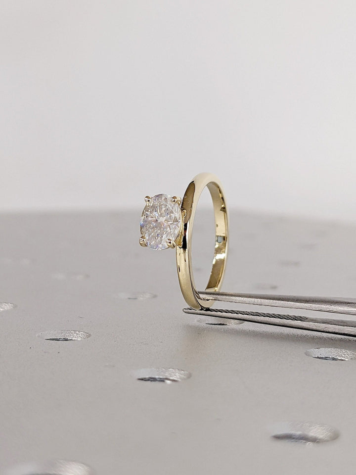 Oval east west diamond ring displayed on jewelry stand