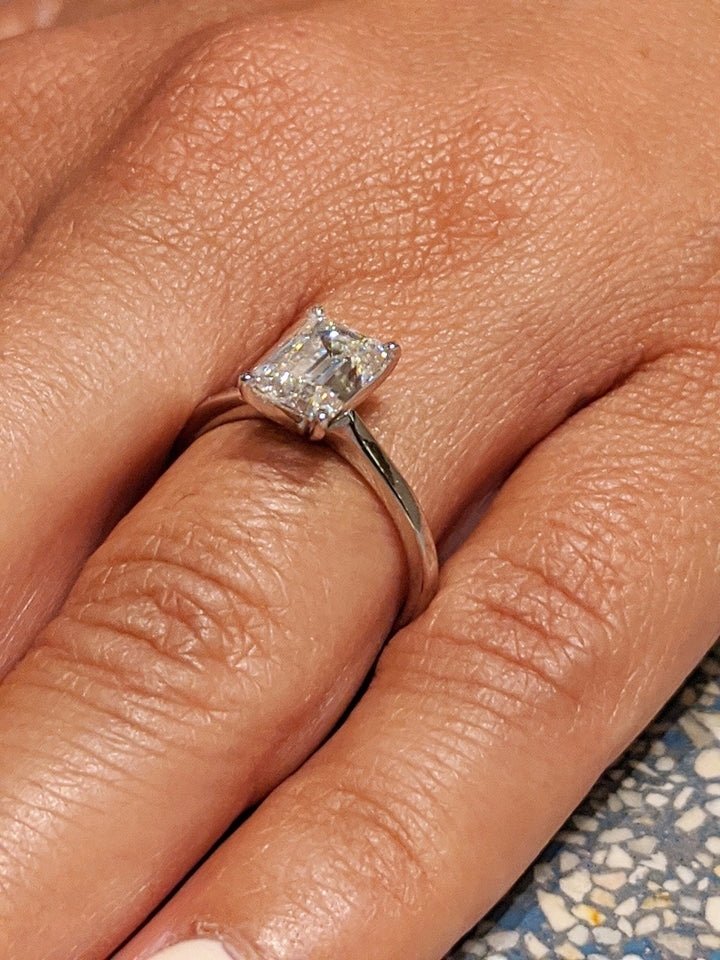 Fine craftsmanship detail on emerald solitaire engagement ring