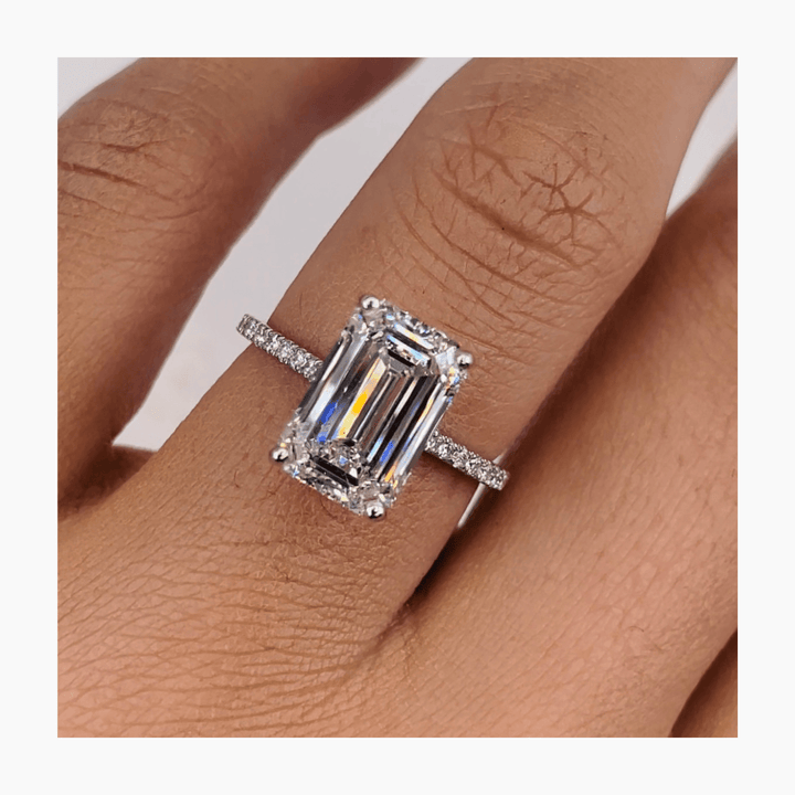 Angled view of emerald cut diamond in pave setting