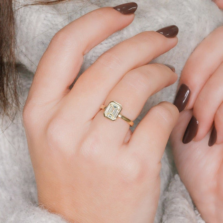 Emerald cut engagement ring shown with authenticity certificate