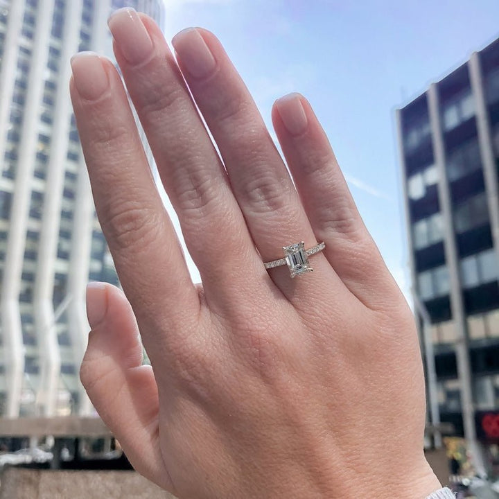 Side angle of emerald hidden halo diamond engagement ring