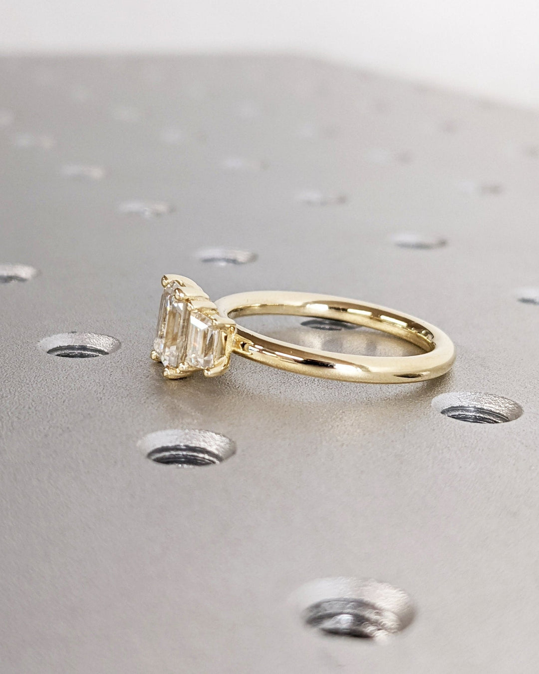 Emerald solitaire diamond ring displayed on jewelry stand