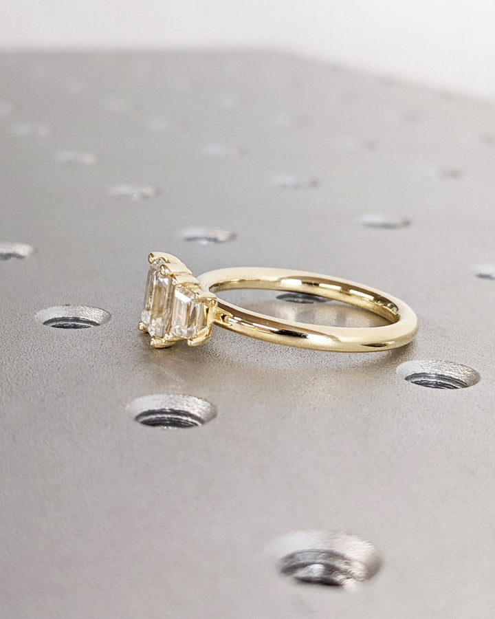 Emerald solitaire diamond ring displayed on jewelry stand