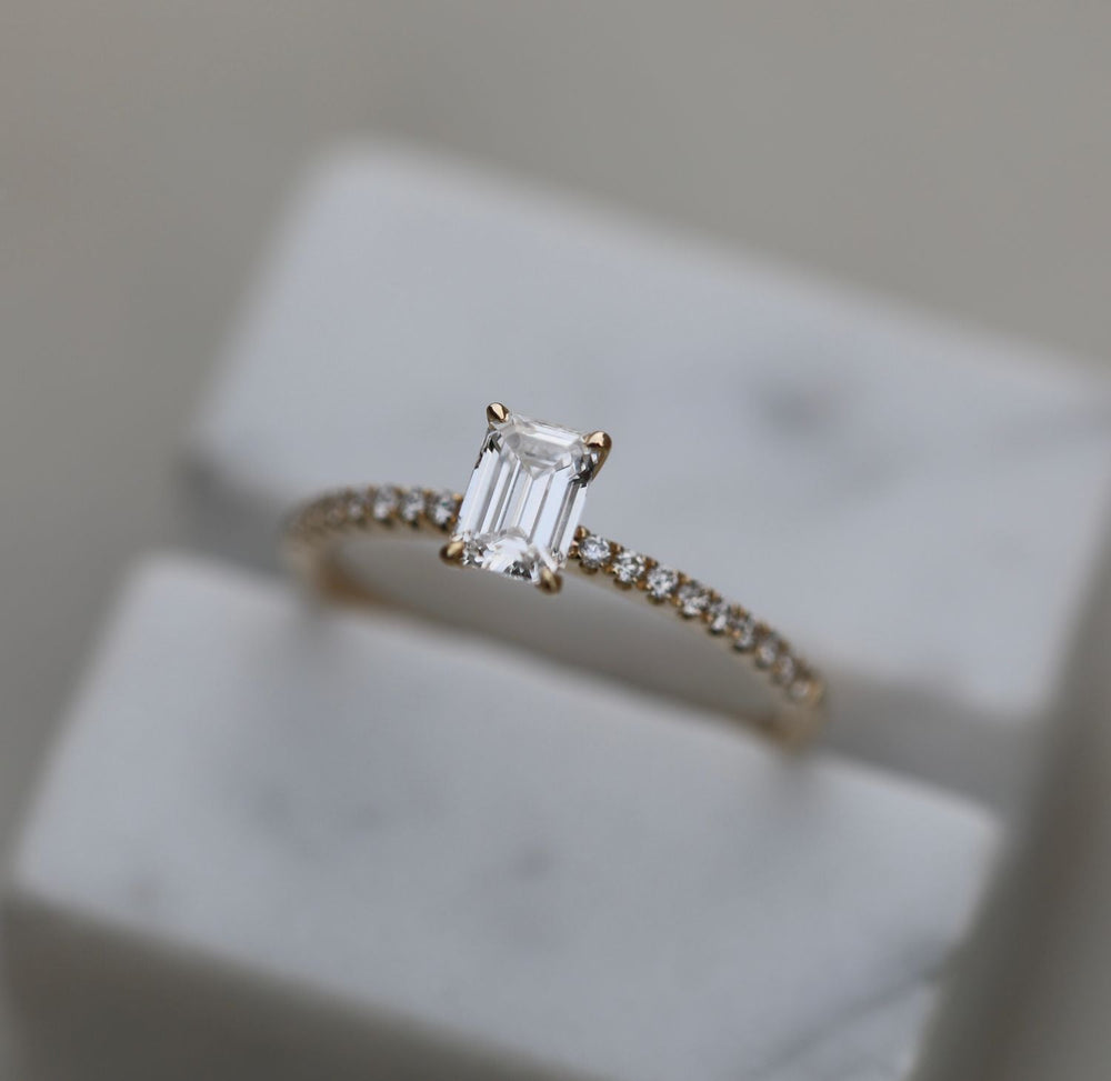 Lifestyle shot of emerald solitaire diamond ring on hand