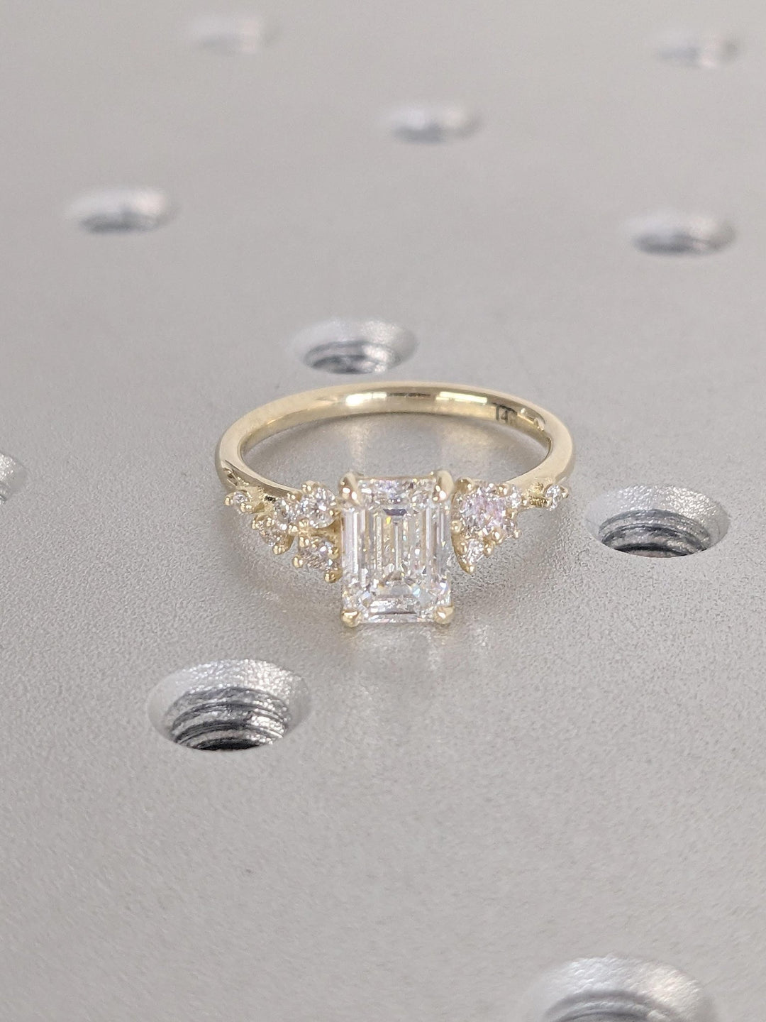 Emerald cluster engagement ring photographed in natural light