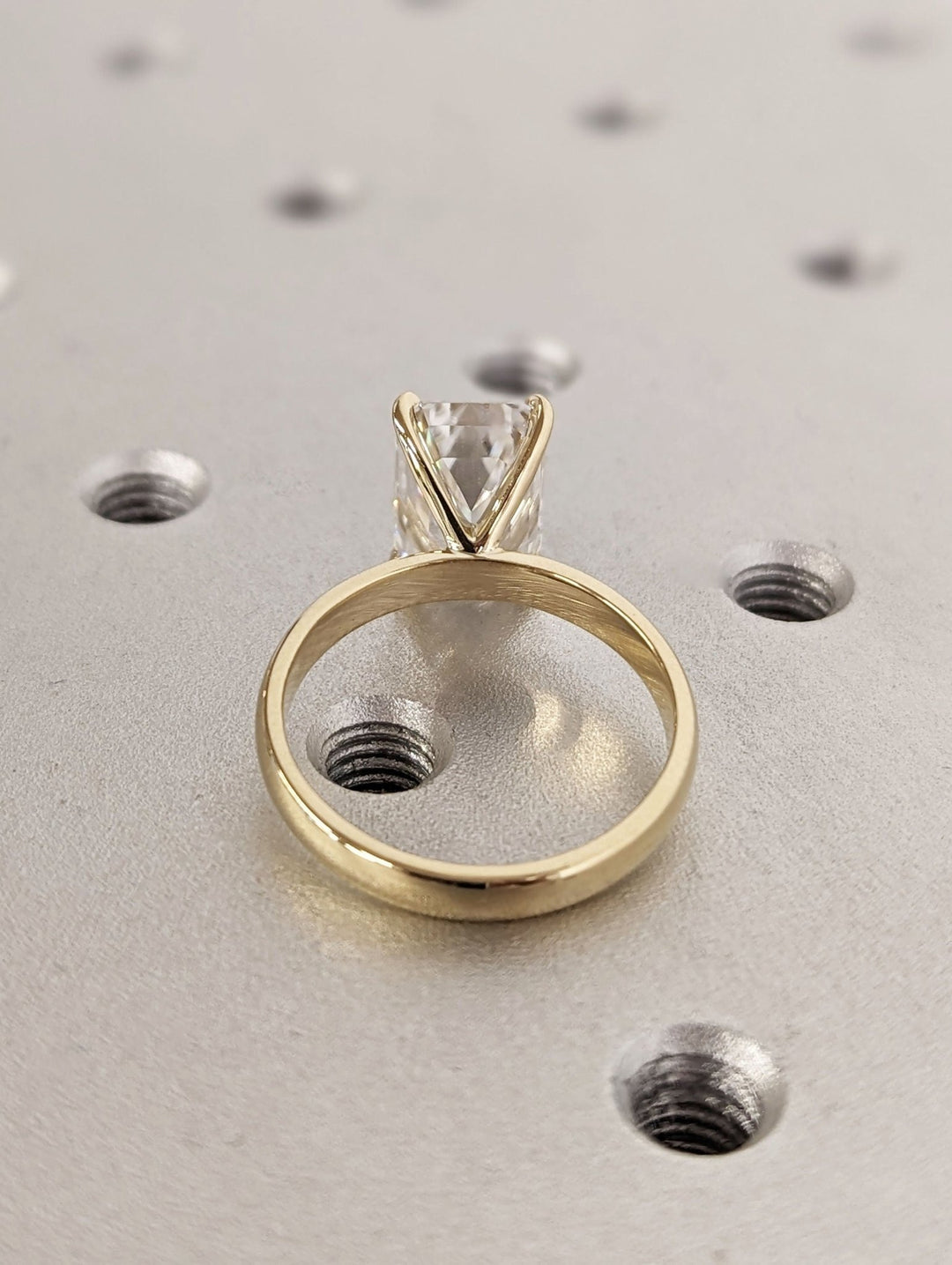 Macro shot of emerald cut diamond facets in solitaire ring setting