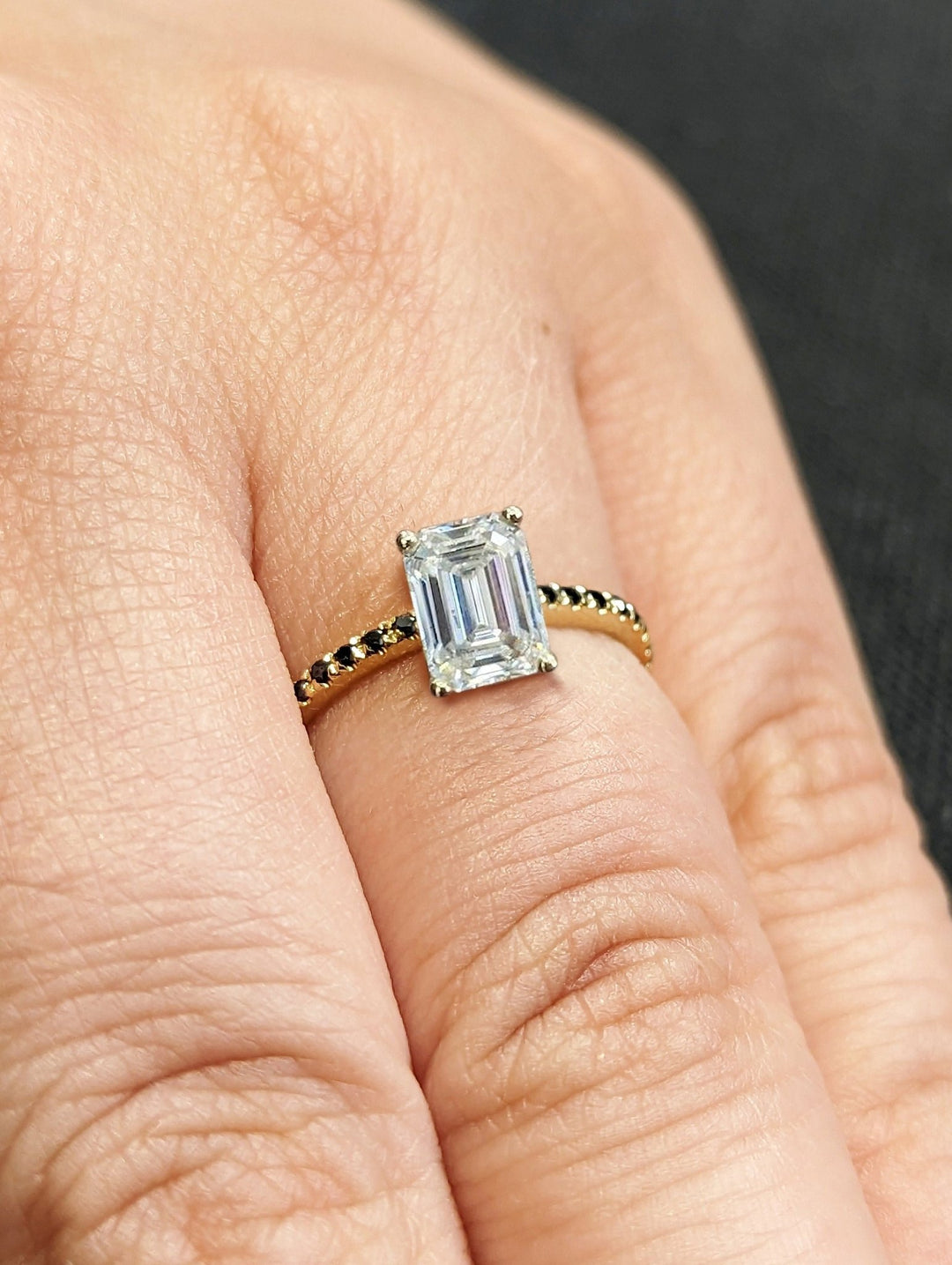 Macro shot of emerald cut diamond facets in pave ring setting