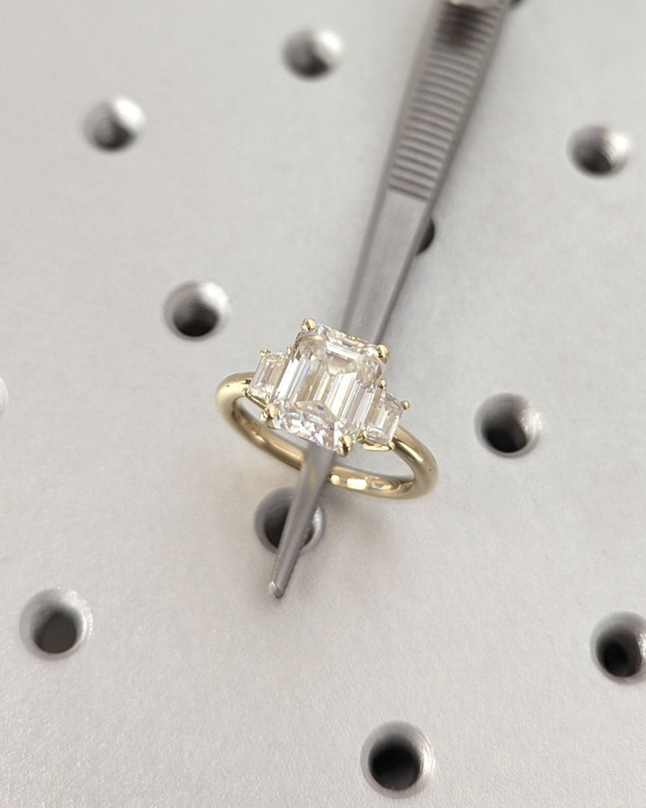 Fine craftsmanship detail on emerald three stone engagement ring
