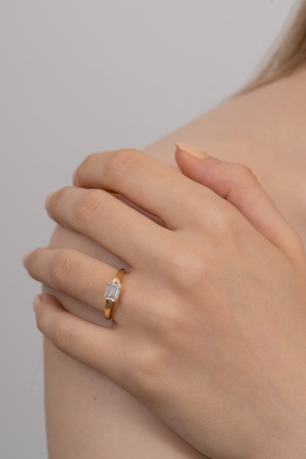 Emerald east west engagement ring with certified lab grown diamond