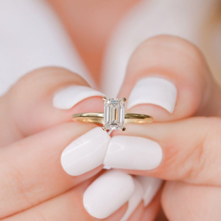 Profile view of emerald cut hidden halo engagement ring band