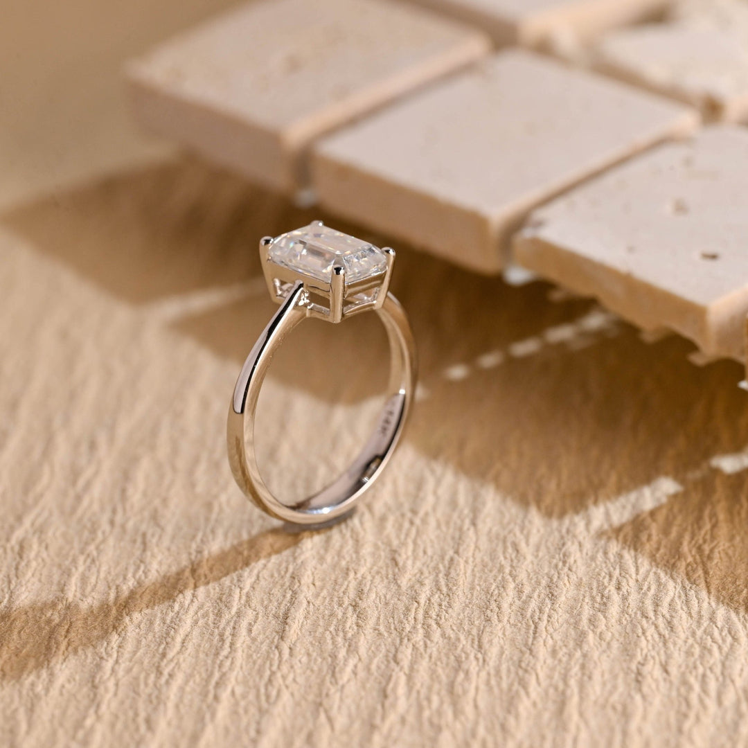 Emerald cut engagement ring shown with authenticity certificate