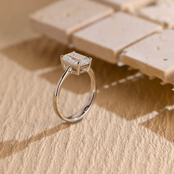 Emerald cut engagement ring shown with authenticity certificate