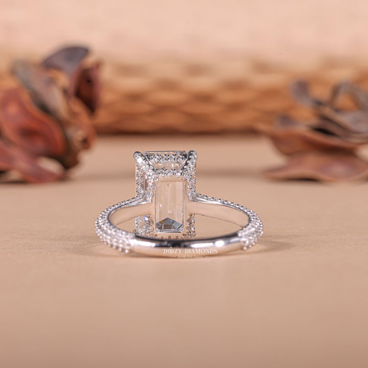 Close-up of emerald cut center diamond in hidden halo engagement ring