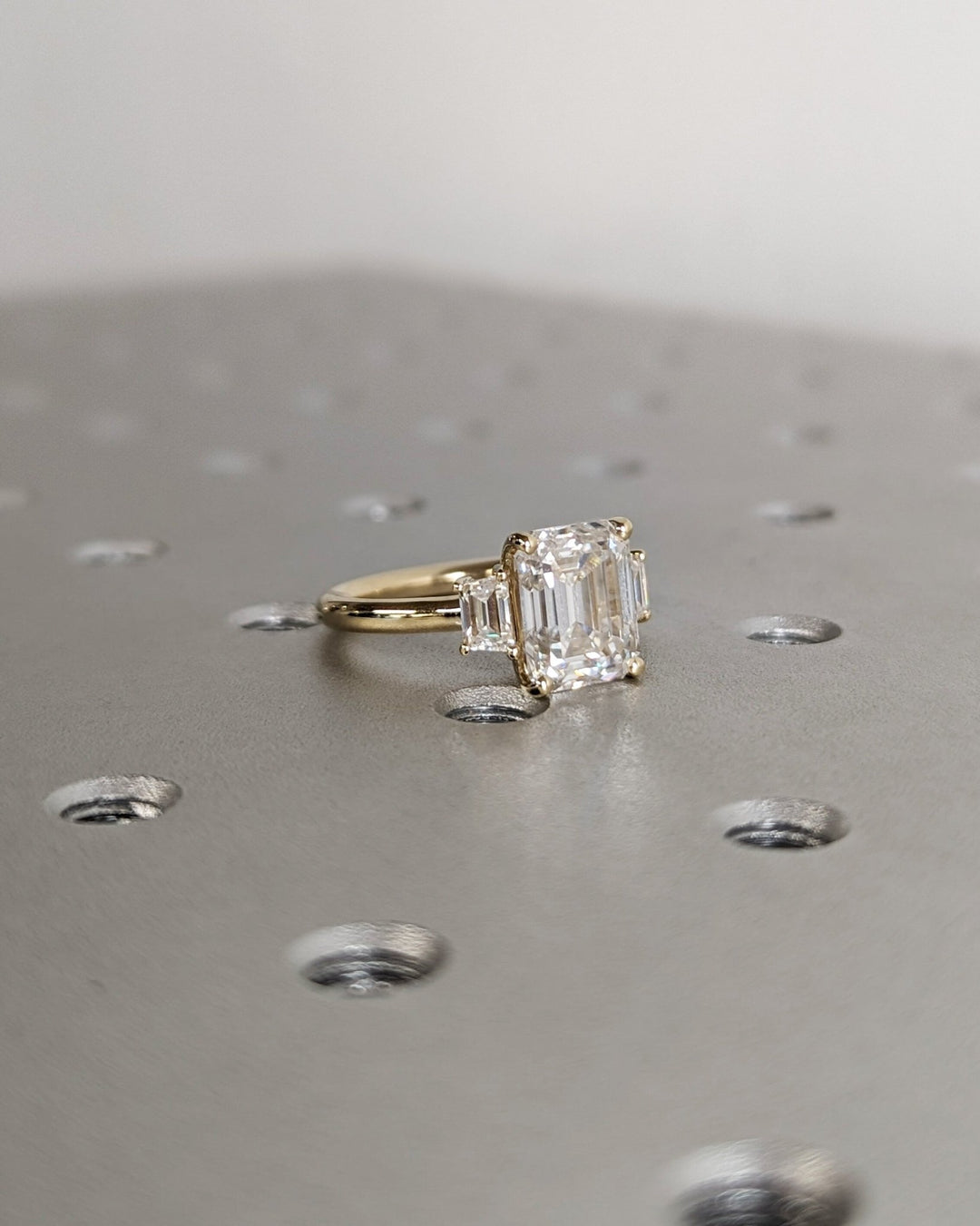 Premium emerald cut three stone engagement ring crafted in solid gold