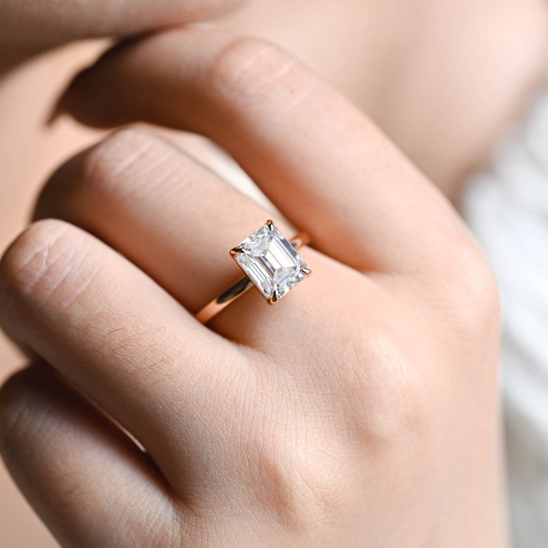 Lifestyle shot of emerald solitaire diamond ring on hand