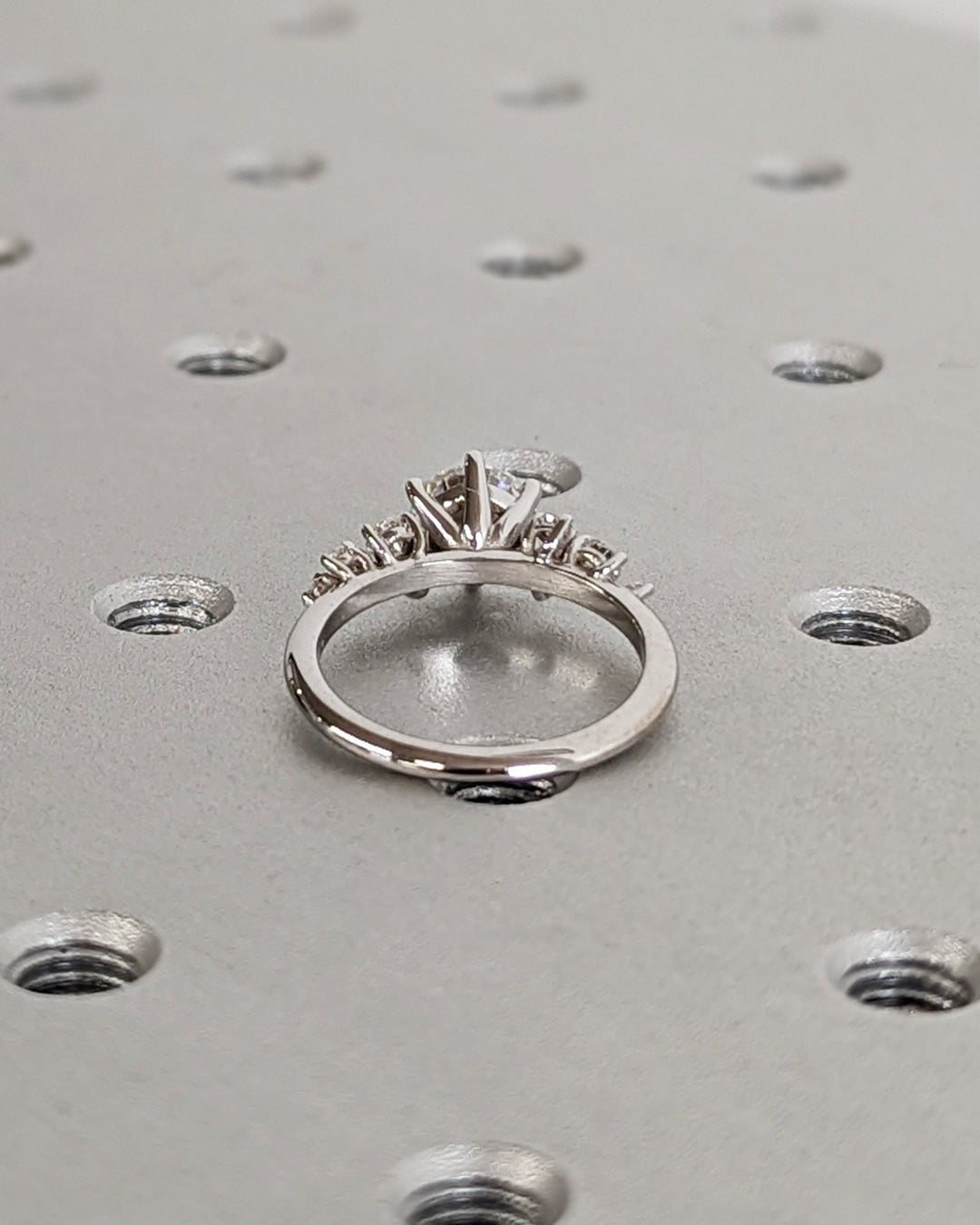 Close-up of round cut center diamond in cluster engagement ring