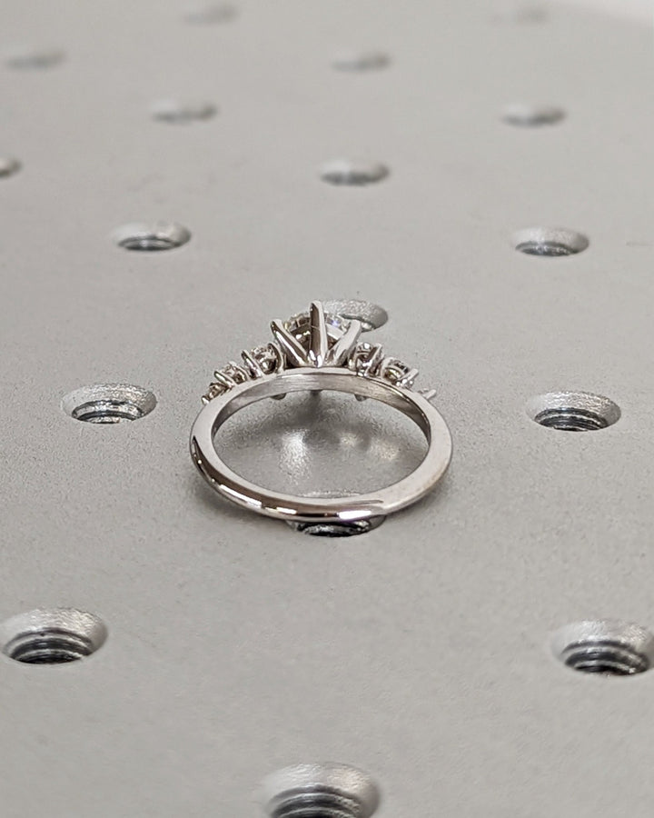 Close-up of round cut center diamond in cluster engagement ring
