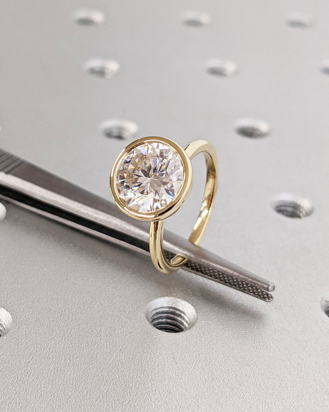 Round bezel lab grown diamond ring fitted on finger