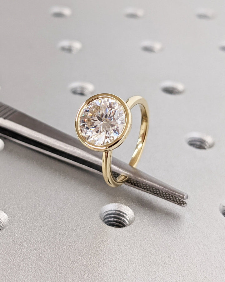 Round bezel lab grown diamond ring fitted on finger