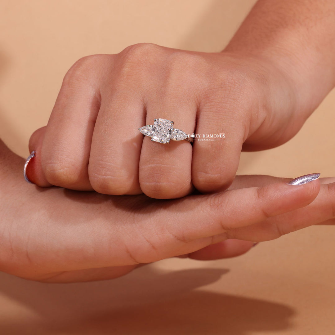 Lifestyle shot of cushion three stone diamond ring on hand