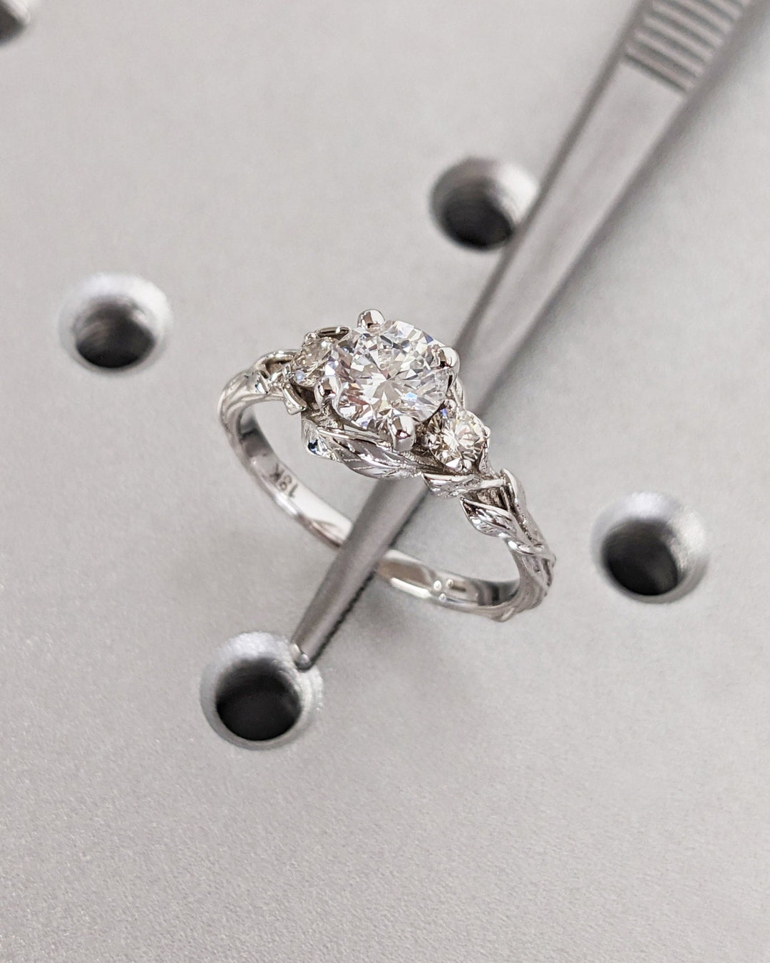 Unboxing view of round cut three stone diamond engagement ring