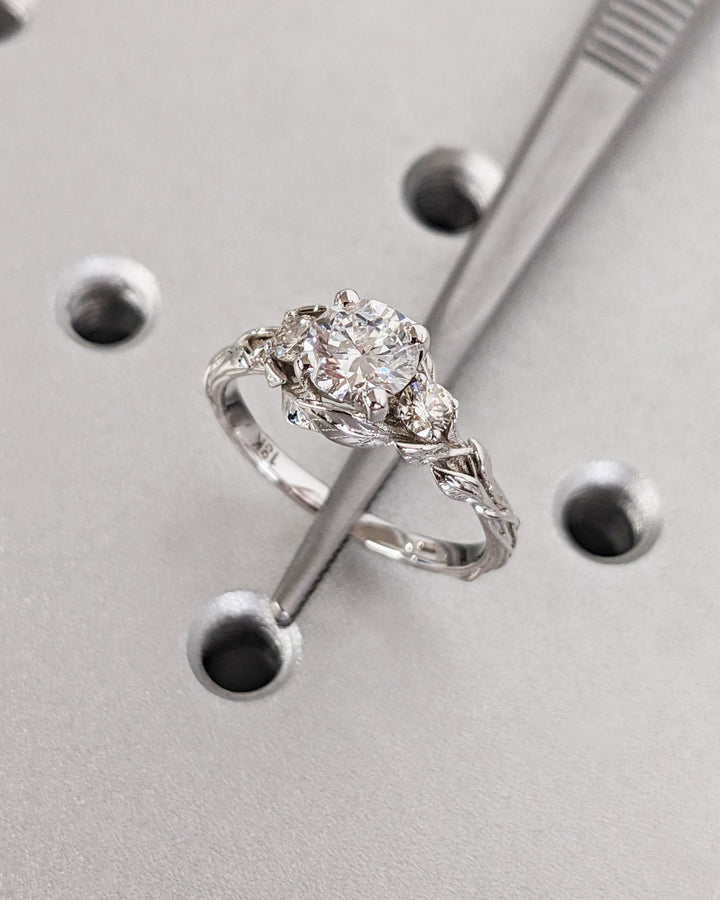 Unboxing view of round cut three stone diamond engagement ring