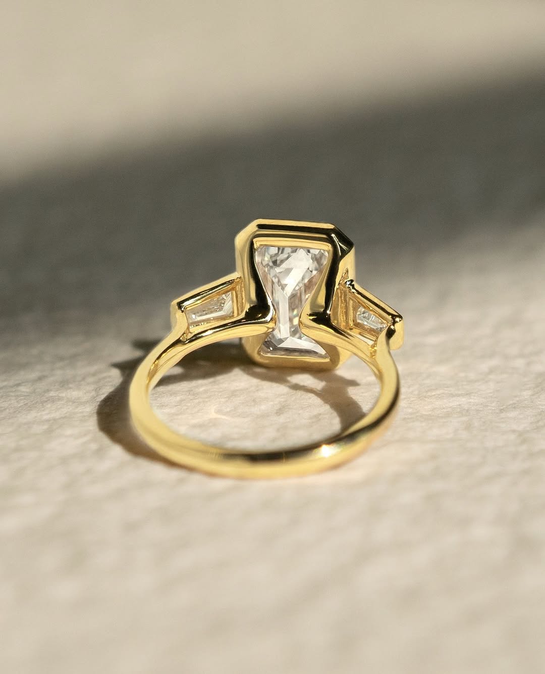 Macro shot of emerald cut diamond facets in bezel ring setting