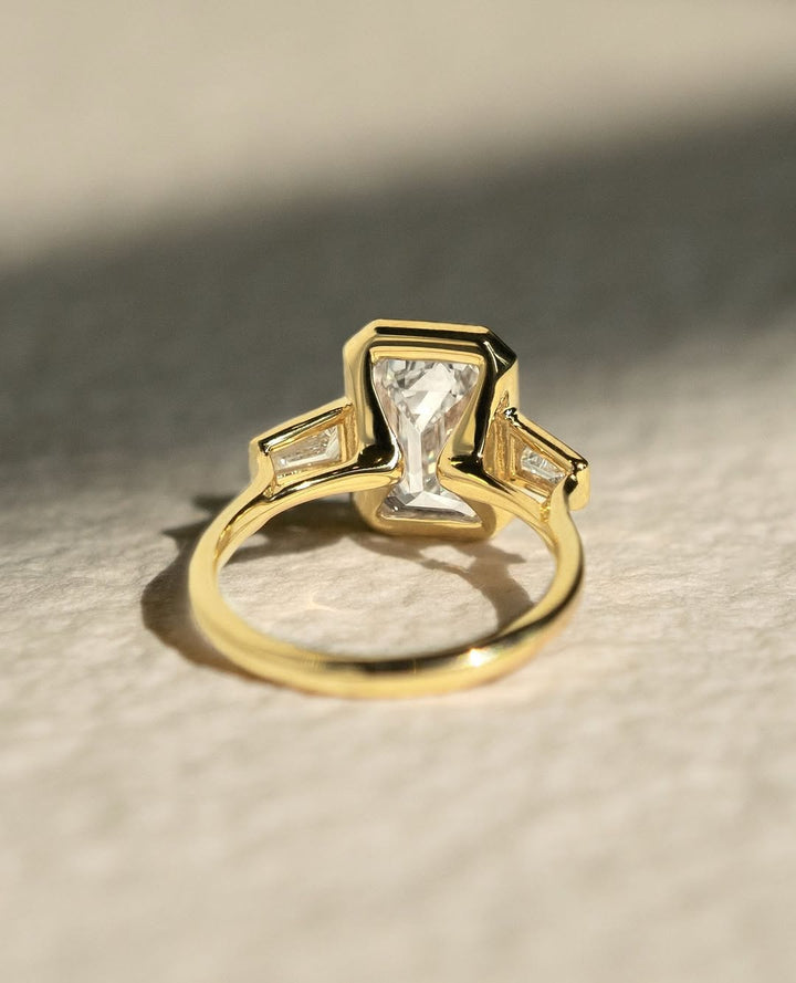 Macro shot of emerald cut diamond facets in bezel ring setting