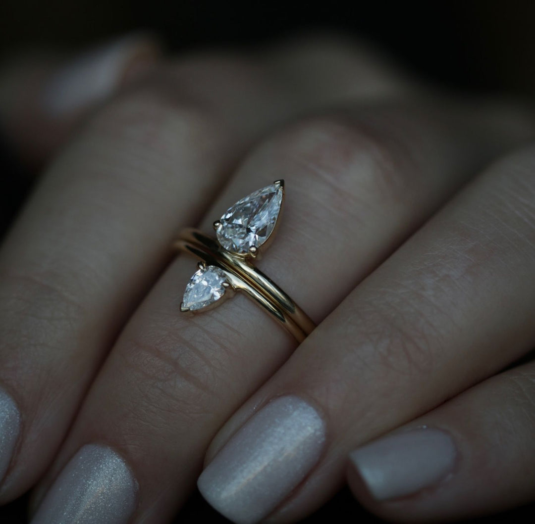 Pear solitaire engagement ring close-up showing F/VVS1 diamond clarity