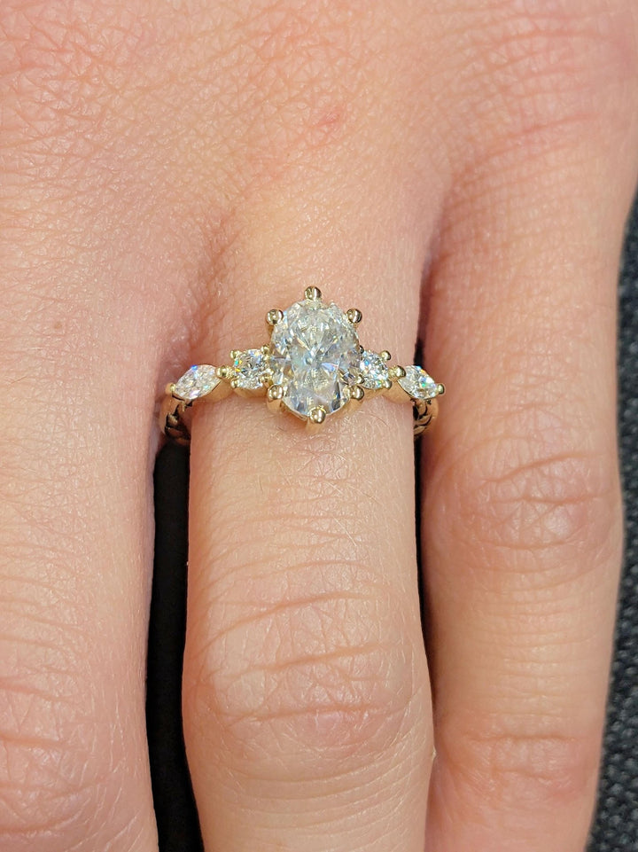 Oval cluster engagement ring viewed from the side