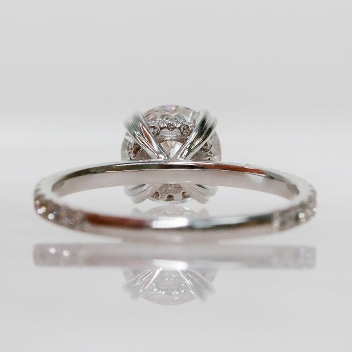 Round hidden halo diamond ring displayed on jewelry stand