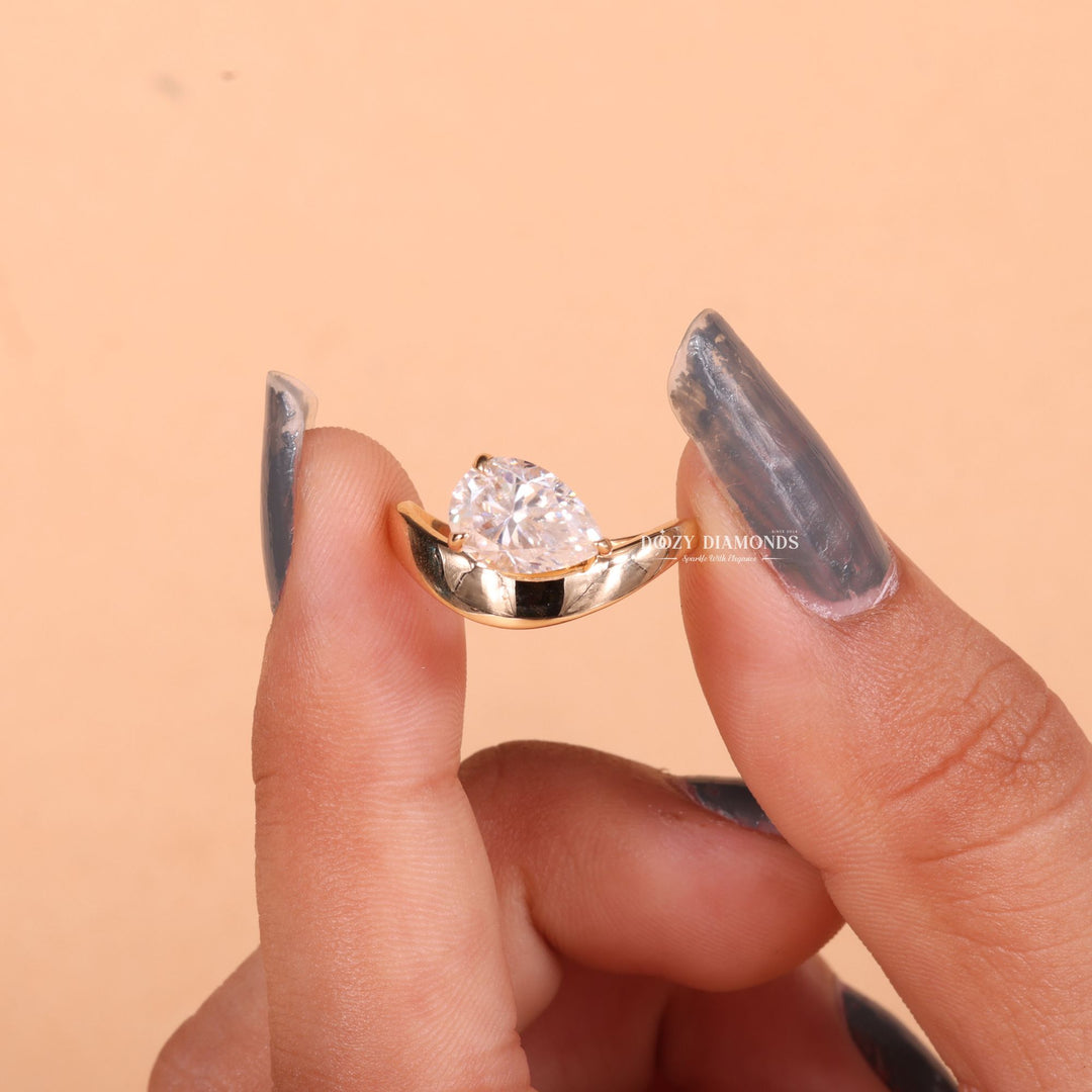Pear east west engagement ring shown on hand for true-to-life sizing