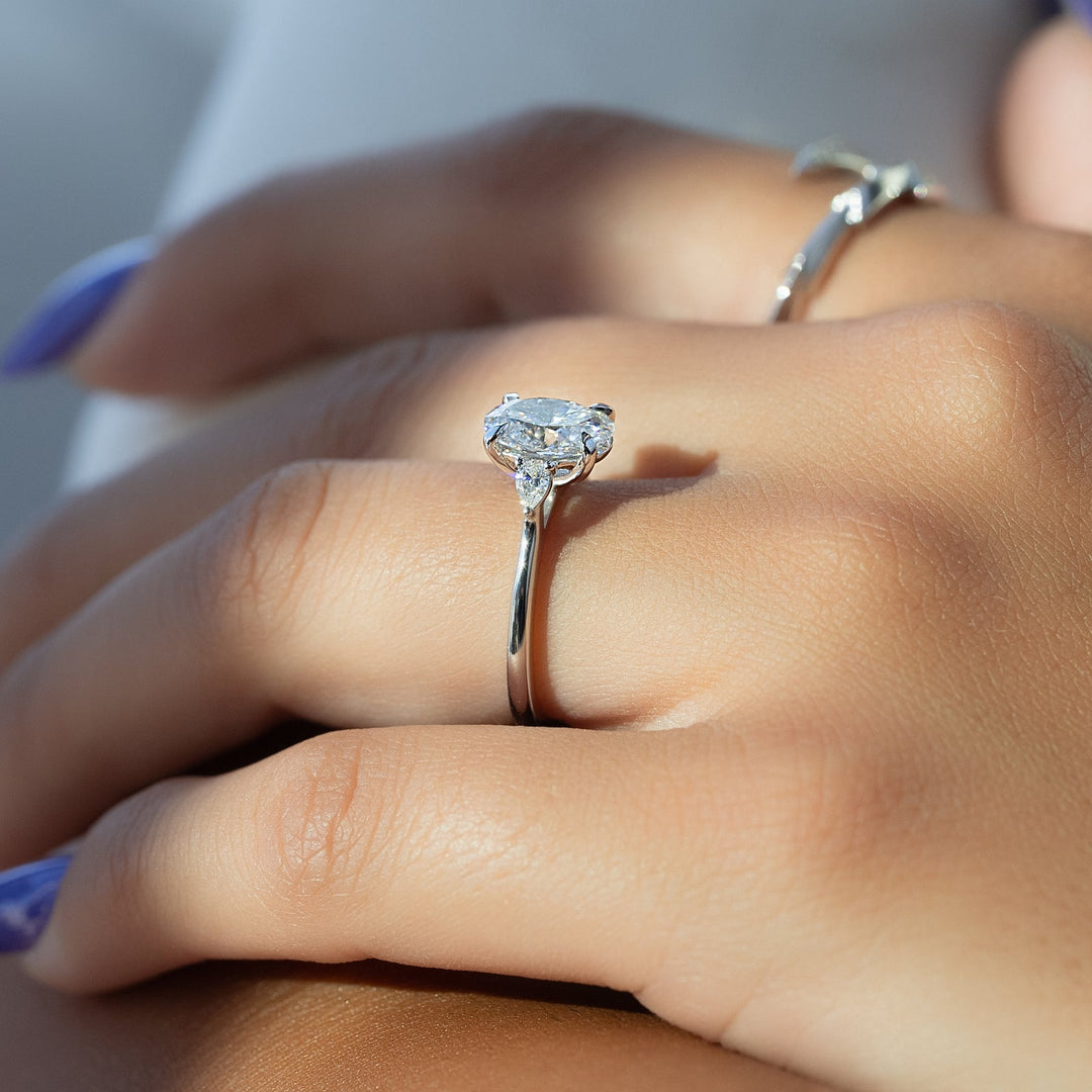 IGI certified oval cut diamond in three stone engagement ring setting