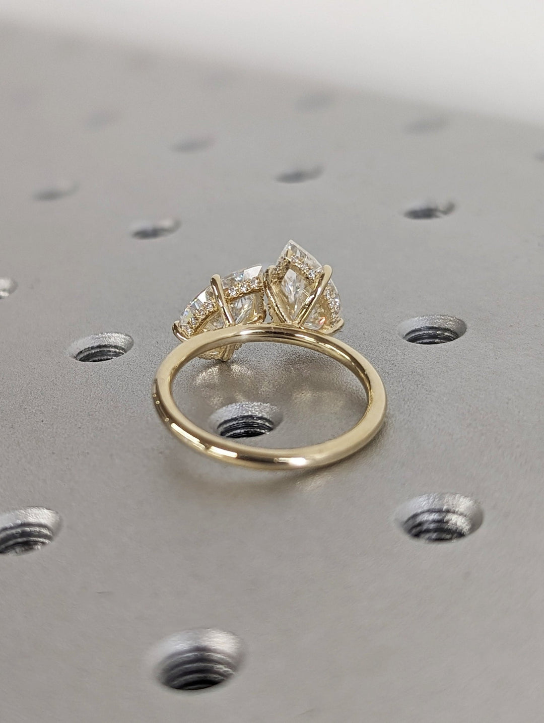 Pear hidden halo engagement ring shown on hand for true-to-life sizing