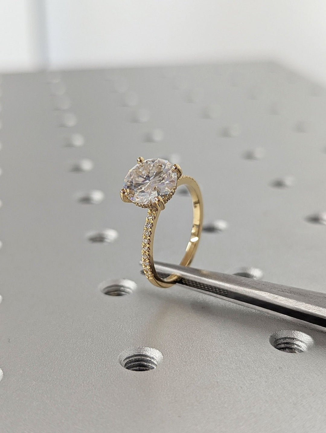 Round hidden halo engagement ring photographed in natural light