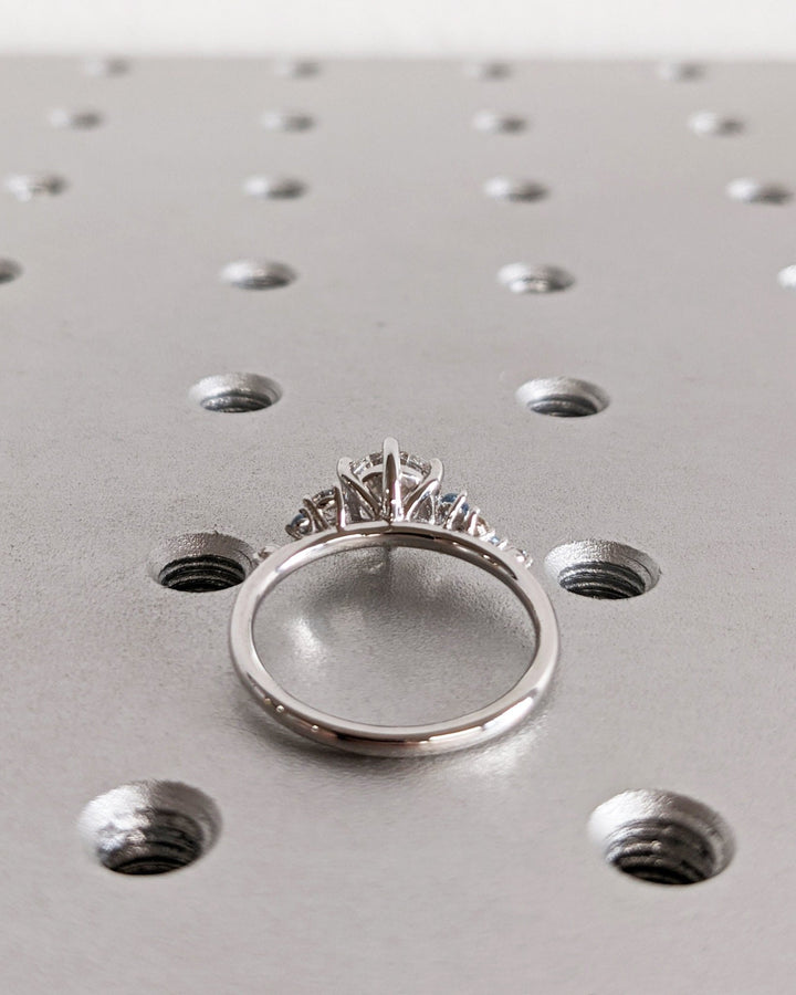 Detailed close-up of round cluster diamond engagement ring
