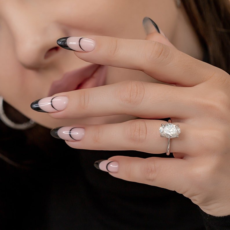 Oval hidden halo engagement ring photographed in natural light