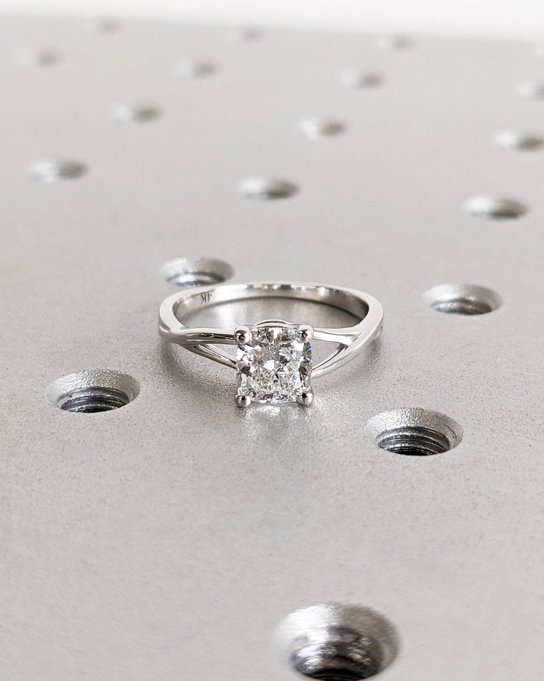 Certified cushion cut diamond featured in split shank engagement ring