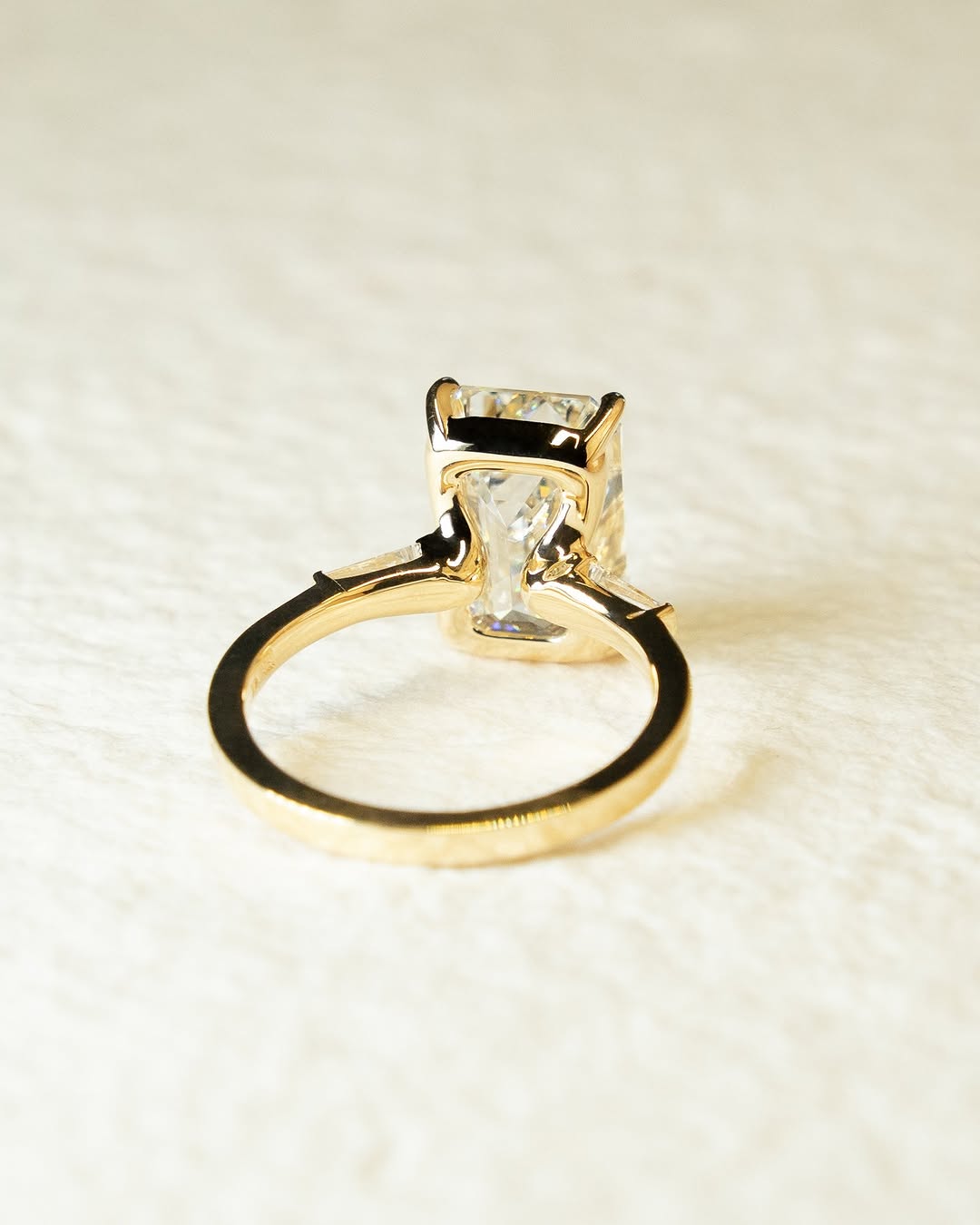 Emerald three stone ring set with an IGI graded diamond