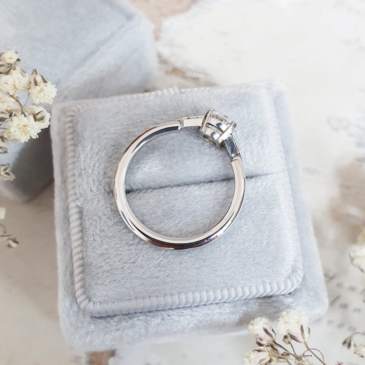 Unboxing view of round cut milgrain diamond engagement ring