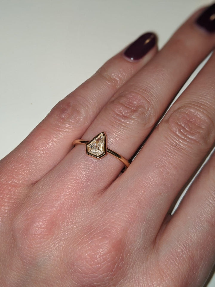 Kite cut engagement ring shown with authenticity certificate