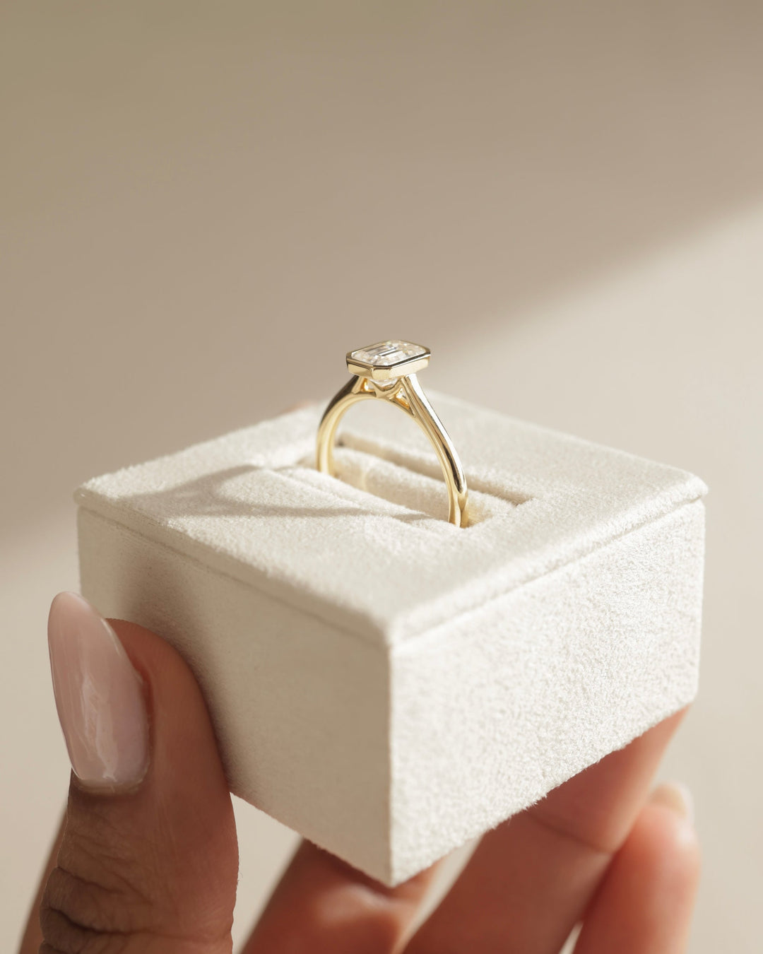Emerald cut bezel engagement ring shown in real-life wear