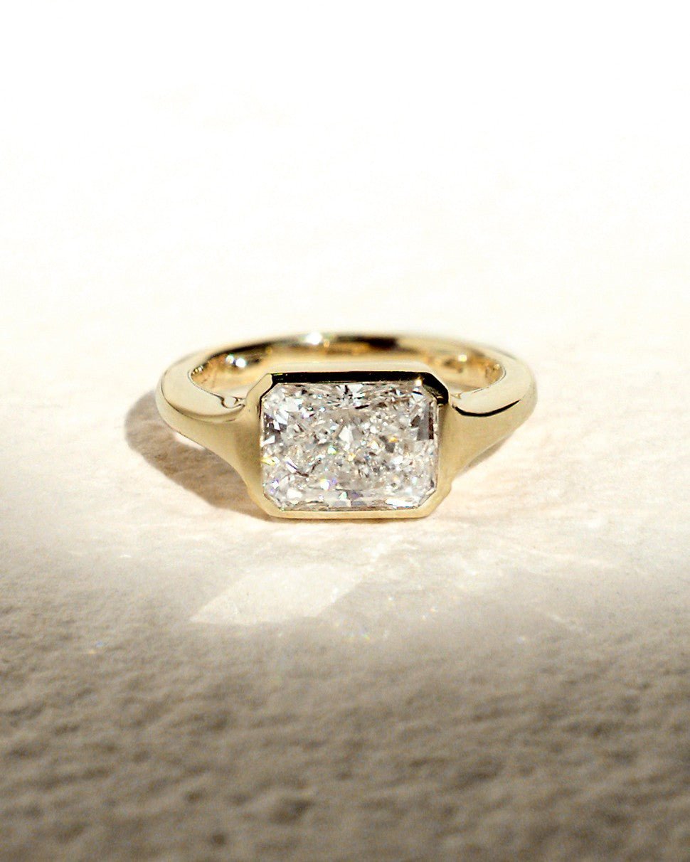 Close-up of radiant cut center diamond in bezel engagement ring