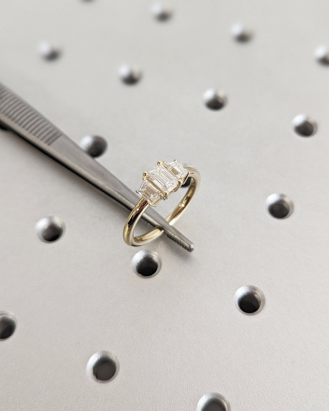 Emerald cut engagement ring shown with authenticity certificate
