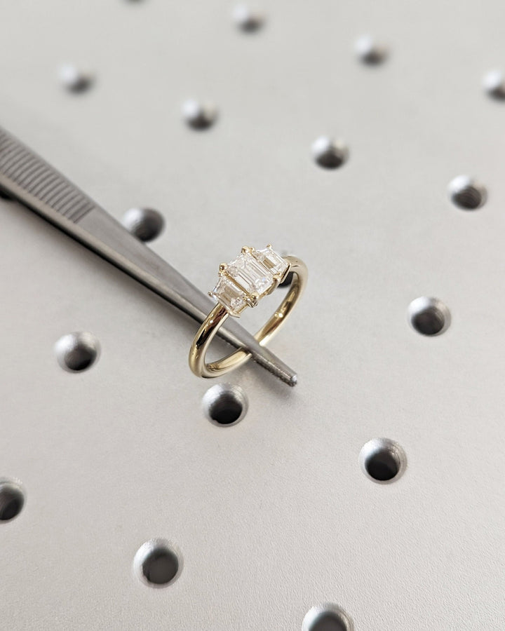 Emerald cut engagement ring shown with authenticity certificate