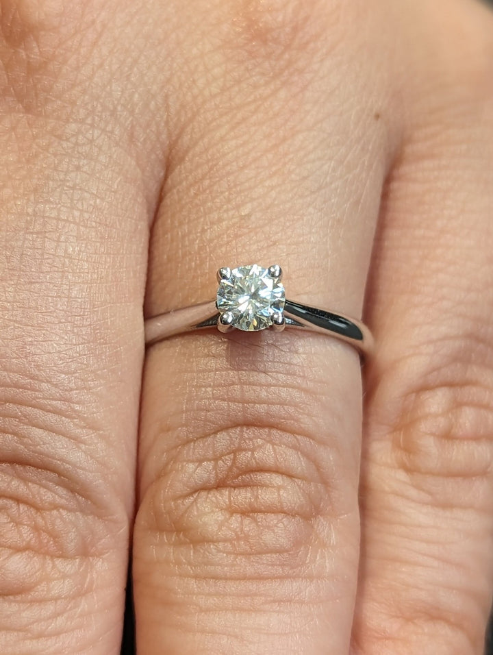 Round cut solitaire engagement ring shown in real-life wear