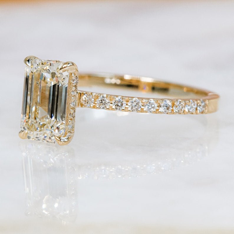 Profile view of emerald cut hidden halo engagement ring band