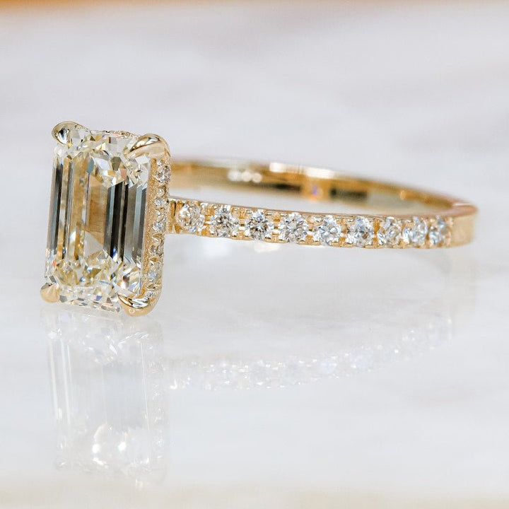 Profile view of emerald cut hidden halo engagement ring band