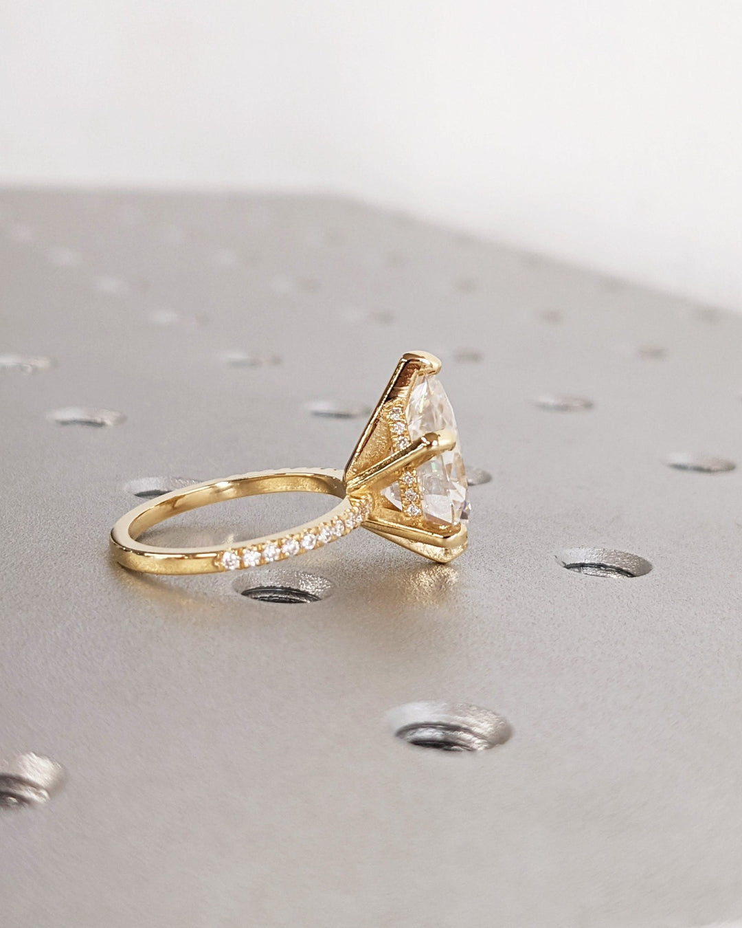 Pear hidden halo engagement ring photographed in natural light