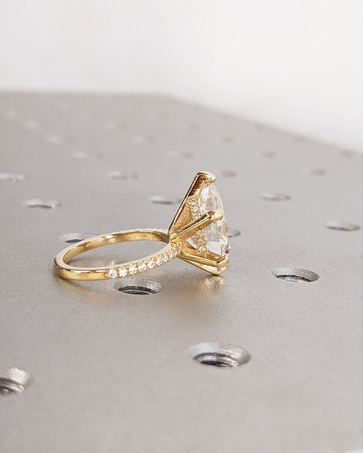 Pear hidden halo engagement ring photographed in natural light
